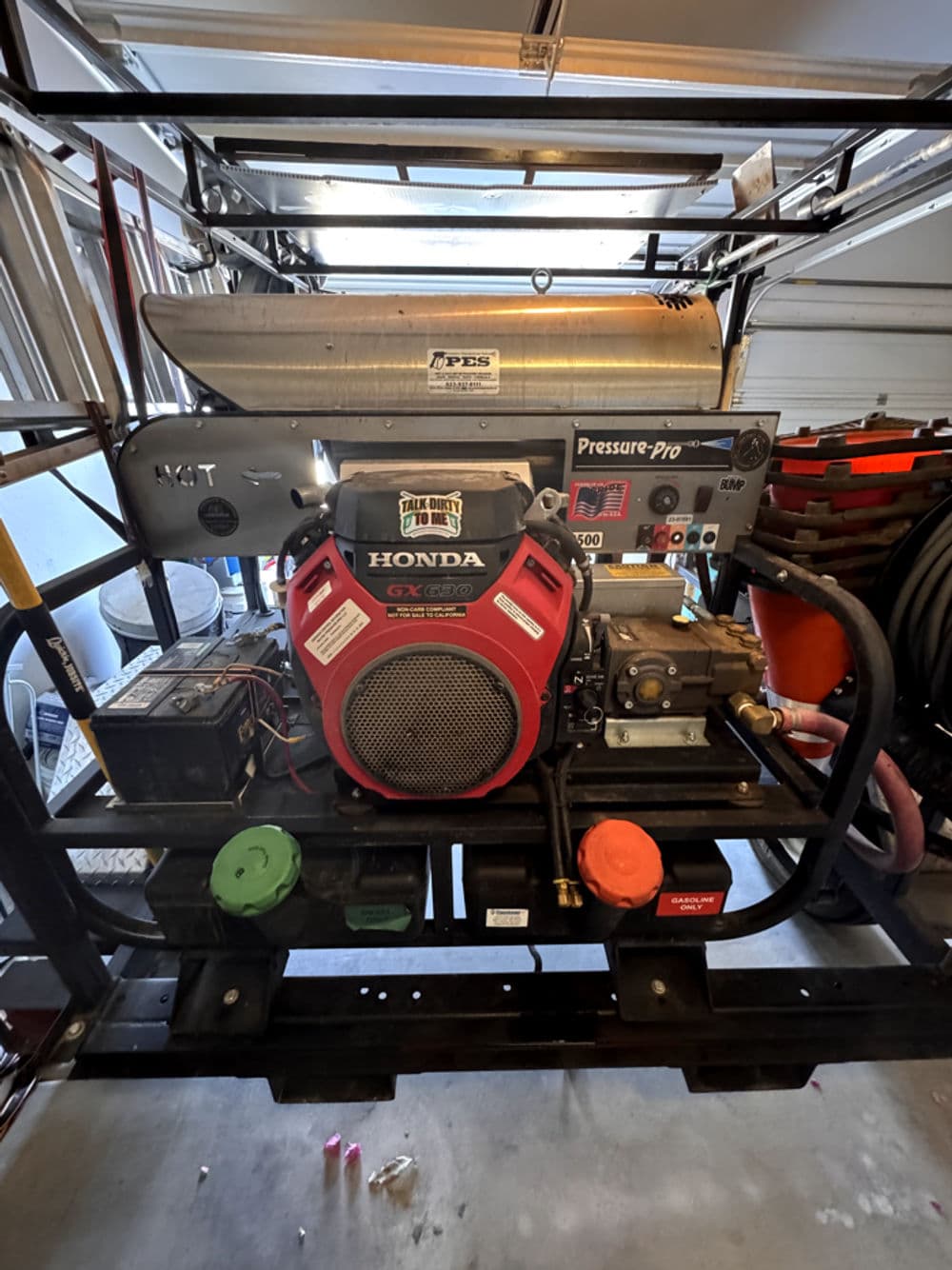 Honda GX390 pressure washer with Pressure-Pro setup in a garage. High-performance cleaning equipment.
